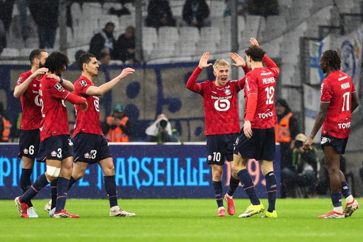 Lille's Belgian defender #12 Thomas Meunier (2R) celebrates with Lille's Icelandic midfielder #10 Hakon Arnar Haraldsson (3R) and teammates after scoring his team first goal during the French L1 football match between Olympique de Marseille (OM) and Lille OSC at the Stade Velodrome in Marseille, southern France on March 22, 2026. Pascal POCHARD-CASABIANCA / AFP