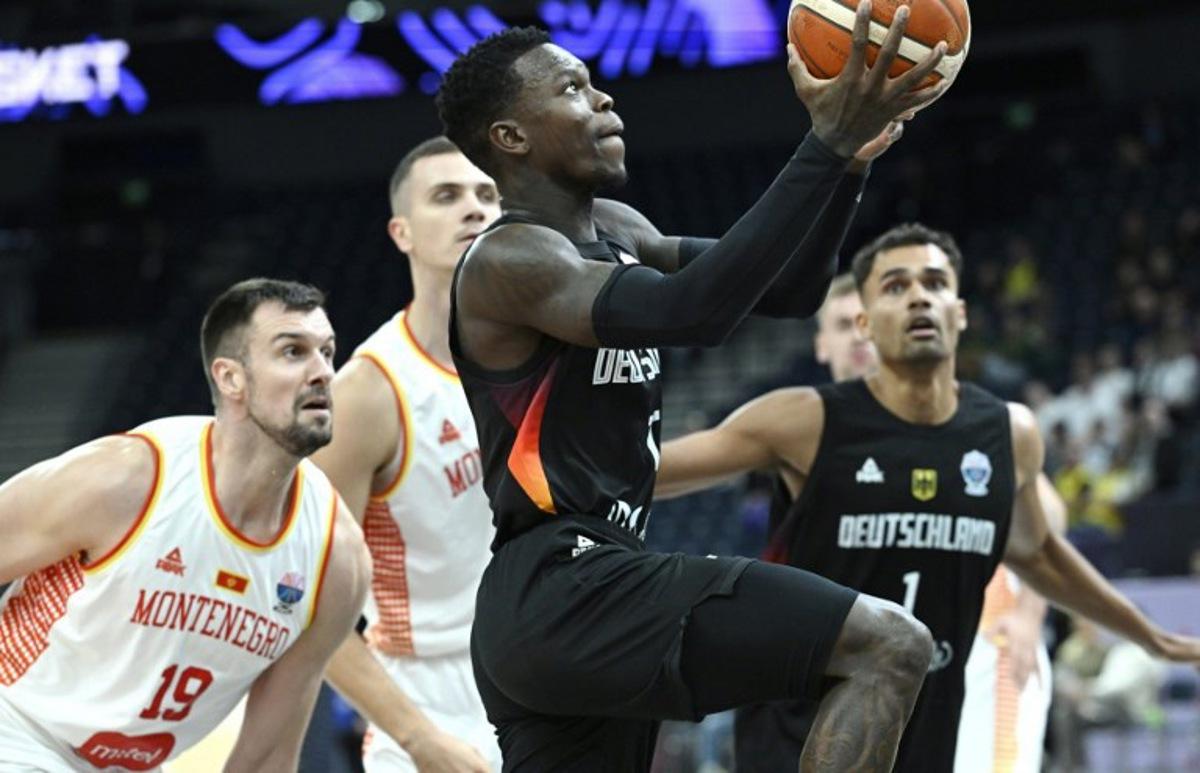 Germany's Dennis Schroder (C) and Montenegro's Zoran Nikolic (L) vie during the FIBA EuroBasket 2025 Group B basketball match between Montenegro and Germany in Tampere, Finland, on August 27, 2025. Heikki Saukkomaa / Lehtikuva / AFP