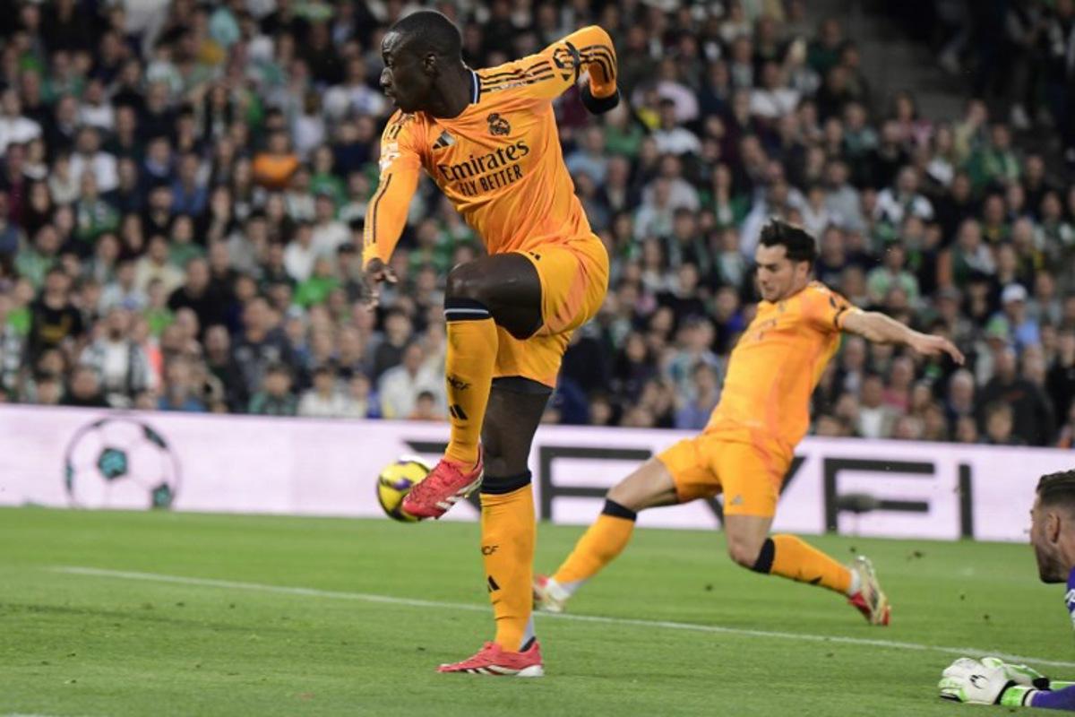 Real Madrid's French defender #23 Ferland Mendy (L) passes the ball to Real Madrid's Moroccan forward #21 Brahim Diaz (R) who scores the opening goal during the Spanish league footbal match between Real Betis and Real Madrid CF at Benito Villamarin Stadium in Seville on March 1, 2025. CRISTINA QUICLER / AFP