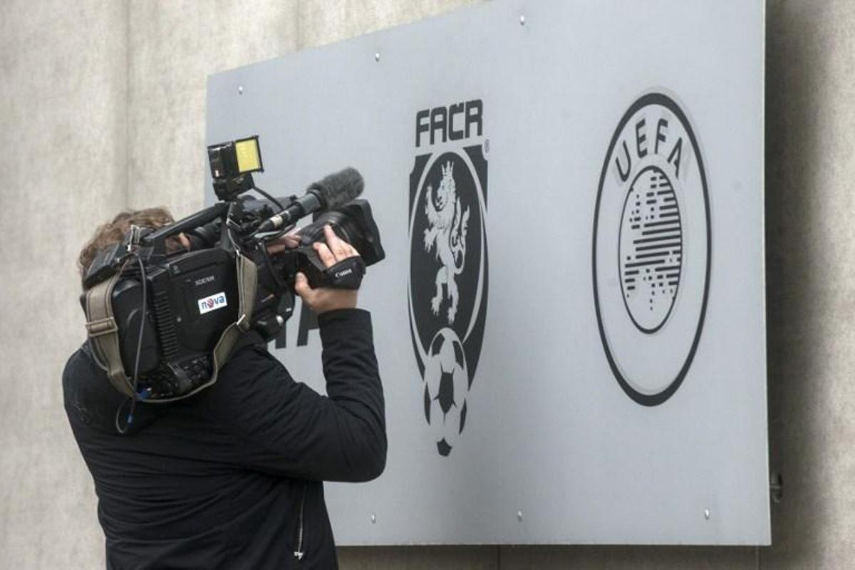 A cameraman of Czech commercial television TV Nova shoots the logo of Czech Football Association (FACR) in front of the FACR headquarters on October 16, 2020 in Prague. Czech police detained 19 people including deputy Czech FA head Roman Berbr over corruption and match-fixing following a nationwide raid, a prosecutor and local media said. Michal Cizek / AFP