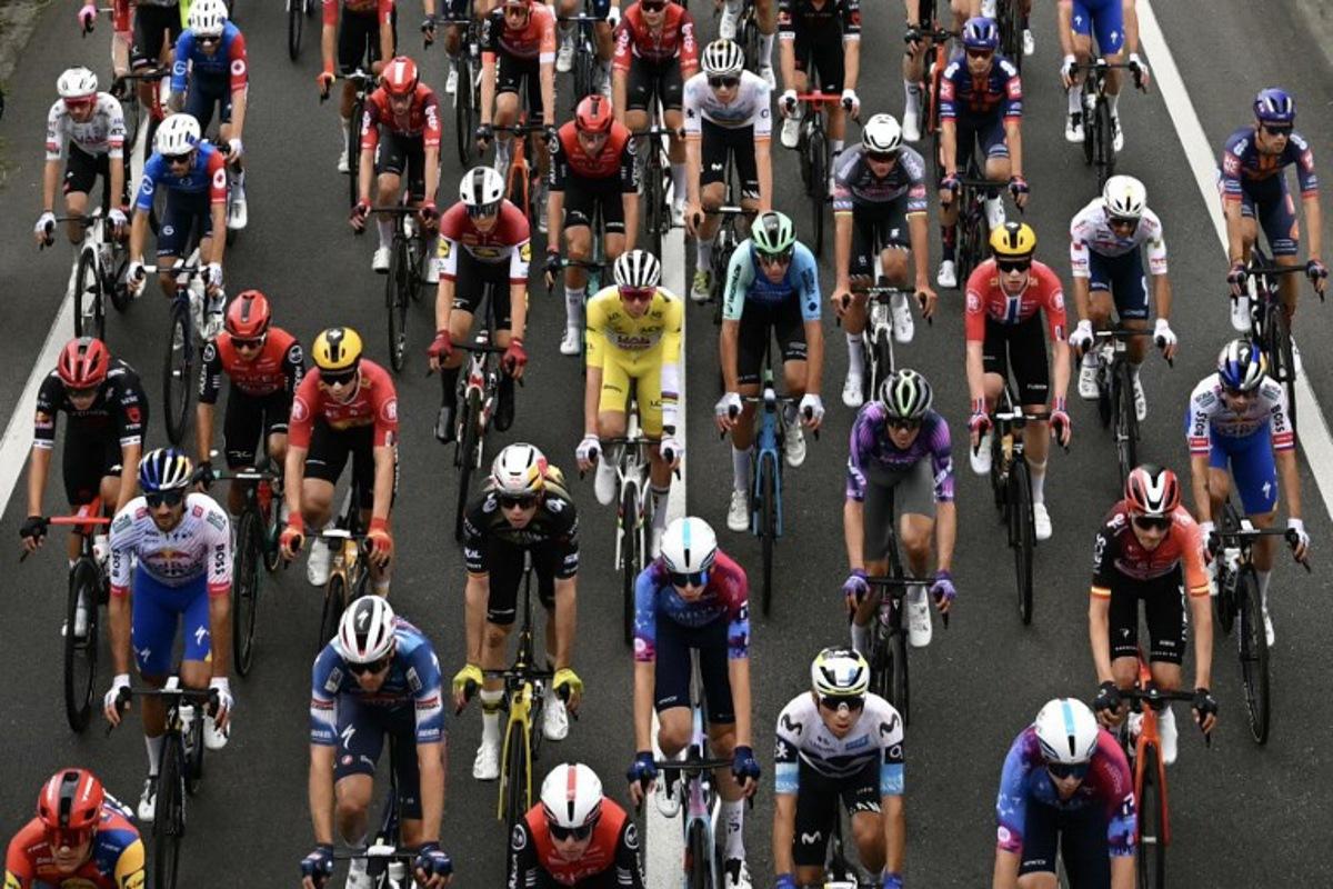 UAE Team Emirates - XRG team's Slovenian rider Tadej Pogacar wearing the overall leader's yellow jersey cycles with the pack of riders (peloton) during the 14th stage of the 112th edition of the Tour de France cycling race, 182.6 km between Pau and Luchon-Superbagneres, in the Pyrenees mountains of southwestern France, on July 19, 2025. Loic VENANCE / AFP