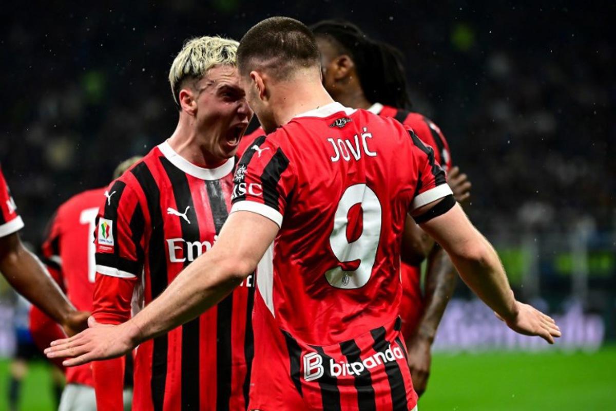 AC Milan's Serbian forward #09 Luka Jovic (R) celebrates with AC Milan's Spanish defender #20 Alejandro Jimenez Sanchez (L) after scoring AC Milan's first goal during the Coppa Italia second leg semi-final football match between Inter Milan and AC Milan at the San Siro stadium in Milan on April 23, 2025. Piero CRUCIATTI / AFP