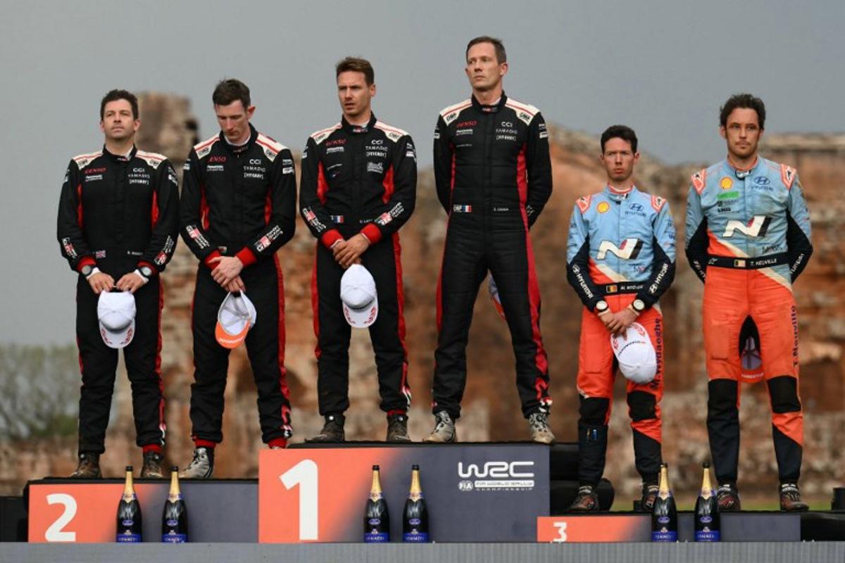 British driver Elfyn Evans (2nd L) and co-driver Scott Martin, French driver Sebastien Ogier (3rd R) and co-driver Vincent Landais, and Belgium driver Thierry Neuville (R) and co-driver Martijn Wydaeghe listen to the anthems at the podium of the WRC Rally Paraguay, 10th stage of the FIA World Rally Championship (WRC), at the Ruins of Trinidad, Itapua department, Paraguay on August 31, 2025. Luis ROBAYO / AFP