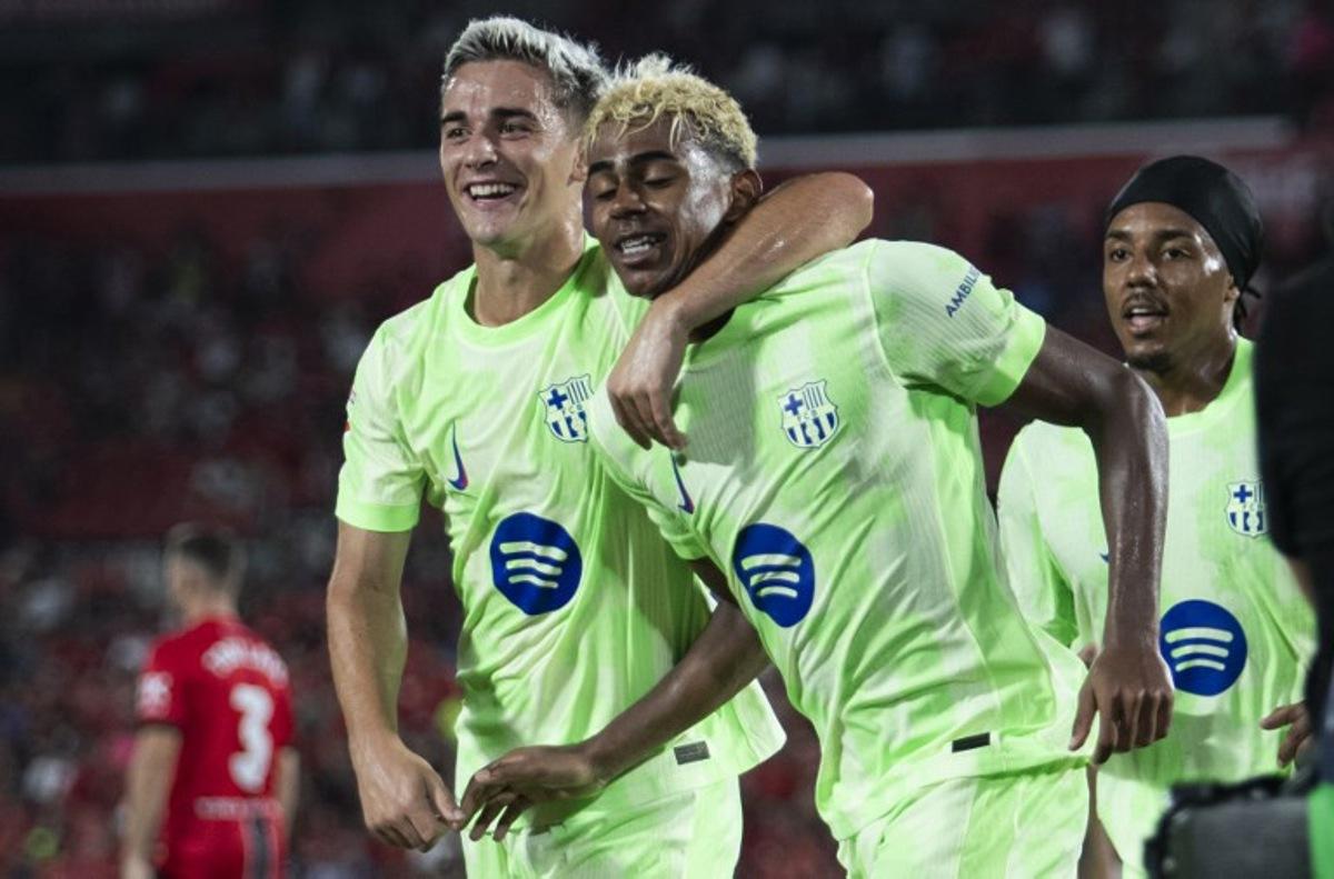 Barcelona's Spanish forward #10 Lamine Yamal (C) celebrates scoring his team's third goal with Barcelona's Spanish midfielder #06 Pablo Gavi (L) during the Spanish league football match between RCD Mallorca and FC Barcelona at Mallorca Son Moix Stadium in Palma de Mallorca on August 16, 2025. JAIME REINA / AFP