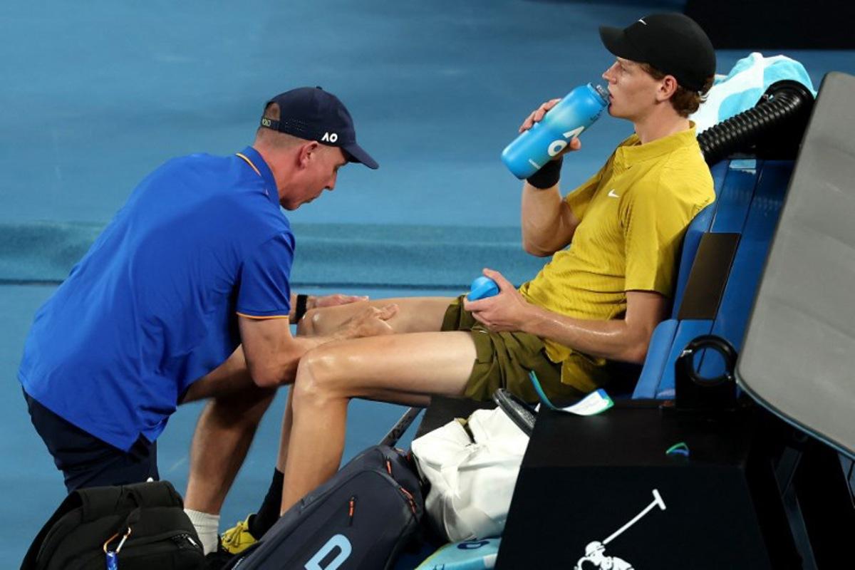 Italy's Jannik Sinner gets medical attention between the games against USA's Eliot Spizzirri during their men's singles match on day seven of the Australian Open tennis tournament in Melbourne on January 24, 2026. Martin KEEP / AFP