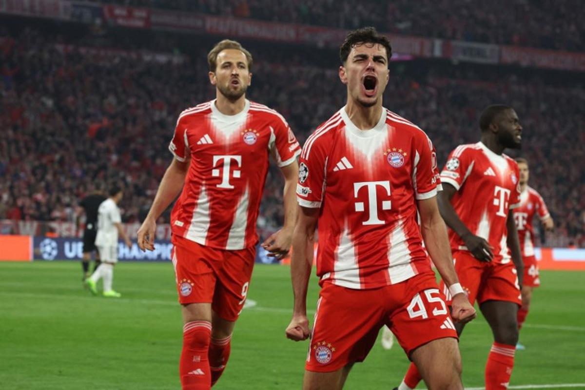 Bayern Munich's German midfielder #45 Aleksandar Pavlovic (C) celebrates followed by Bayern Munich's English forward #09 Harry Kane (L) after scoring the 1-1 equalizing goal during the UEFA Champions League quarter-final second leg football match between FC Bayern Munich and Real Madrid in Munich, southern Germany, on April 15, 2026. Karl-Josef HILDENBRAND / AFP
