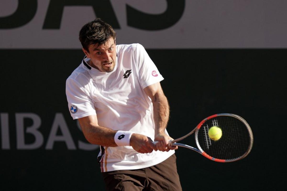 Austria's Sebastian Ofner plays a backhand return to Italy's Luciano Darderi during their men's singles match on day 3 of the French Open tennis tournament at the Roland-Garros Complex in Paris on May 26, 2026. Dimitar DILKOFF / AFP