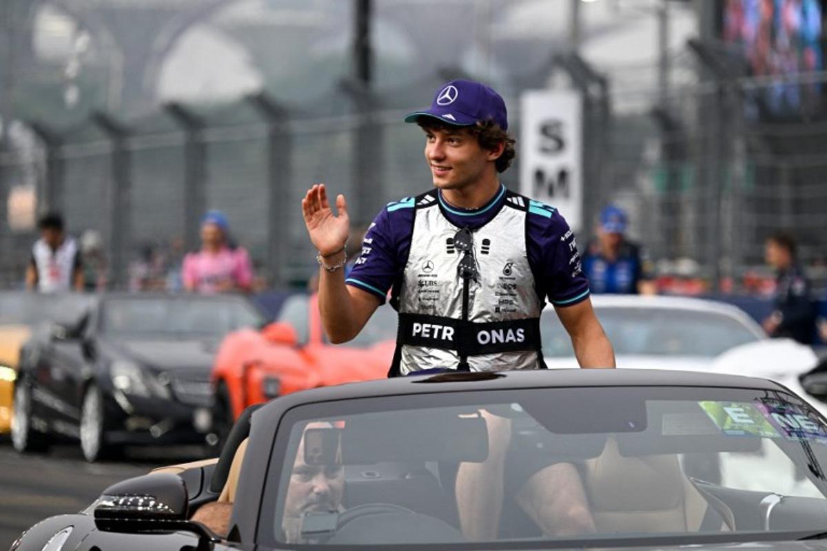 Mercedes' Italian driver Kimi Antonelli waves to the crowd during the drivers' parade before the start of the Formula One Singapore Grand Prix at the Marina Bay Street Circuit in Singapore on October 11, 2026. ROSLAN RAHMAN / AFP