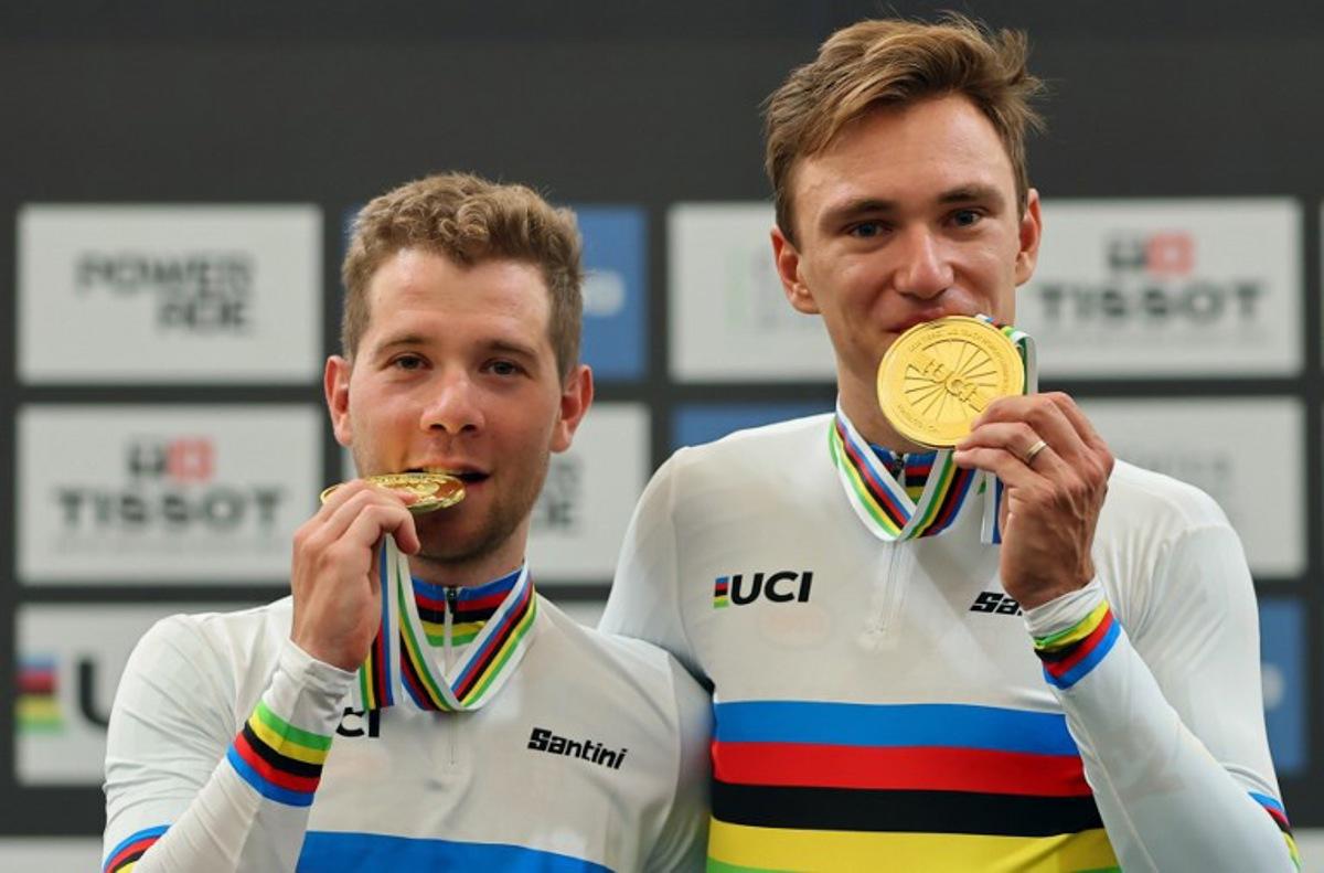 Belgium's Fabio Van den Bossche (L) and Lindsay De Vylder bite their gold medals during the men's madison 50km event award ceremony at the 2025 UCI Track World Championships, in the Penalolen Velodrome in Santiago, on October 26, 2025. Javier TORRES / AFP