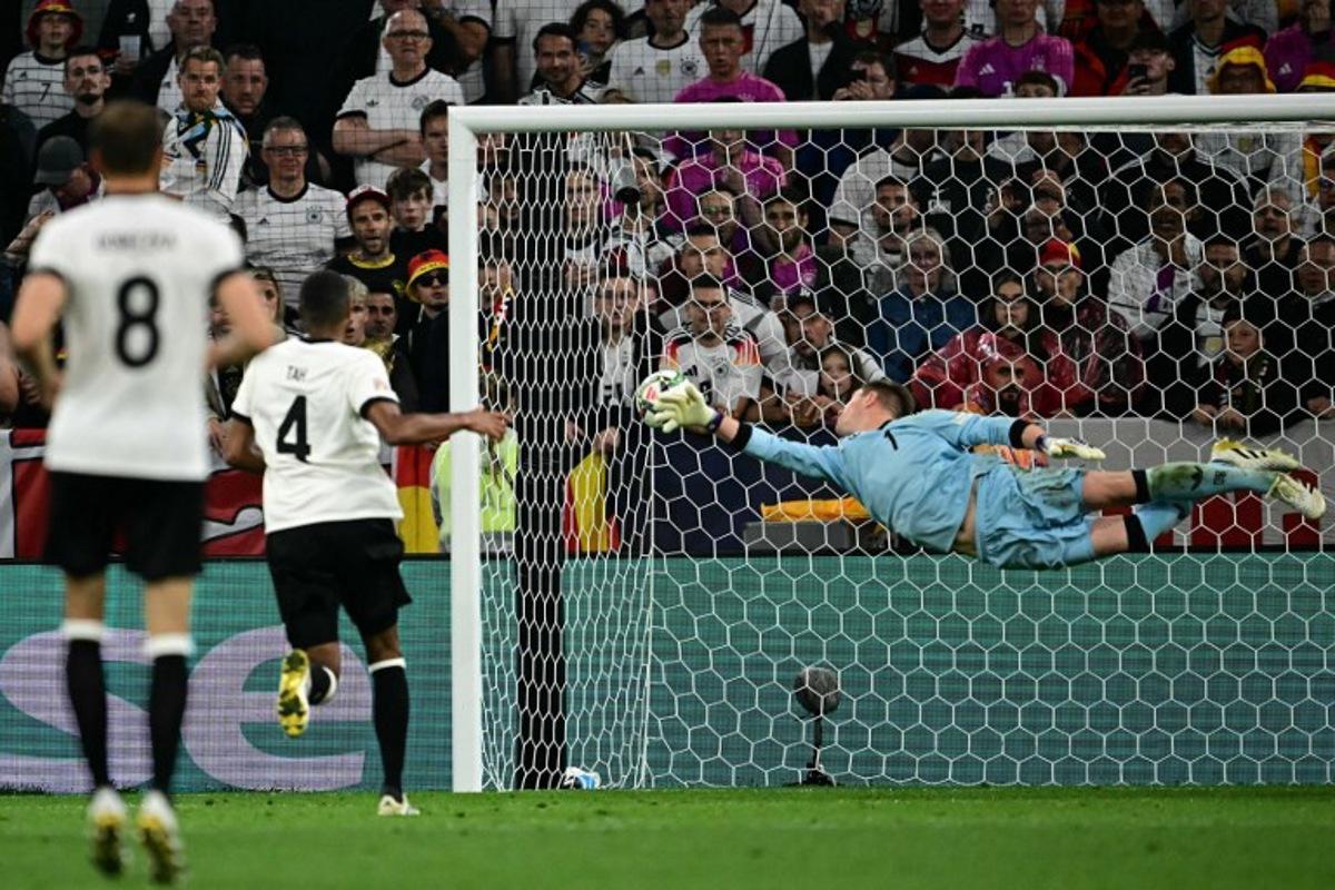 Germany's goalkeeper #01 Marc-Andre Ter Stegen dives but fails to save the 1-1 goal during the UEFA Nations League semi-final football match between Germany and Portugal in Munich, southern Germany on June 4, 2025. Tobias SCHWARZ / AFP