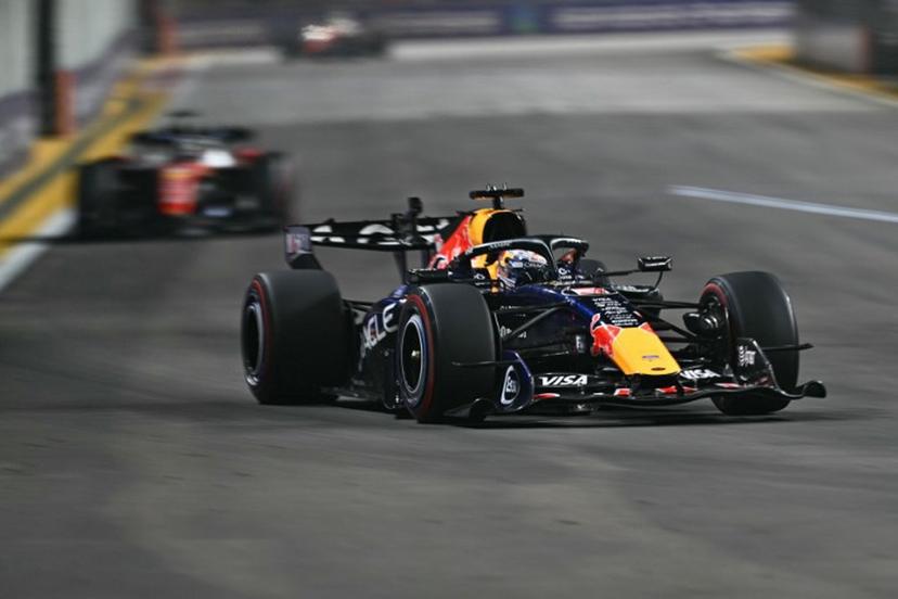 Red Bull Racing's Dutch driver Max Verstappen drives in front of Ferrari's Monegasque driver Charles Leclerc during the Formula One Singapore Grand Prix at the Marina Bay Street Circuit in Singapore on October 11, 2026. ANTHONY WALLACE / AFP