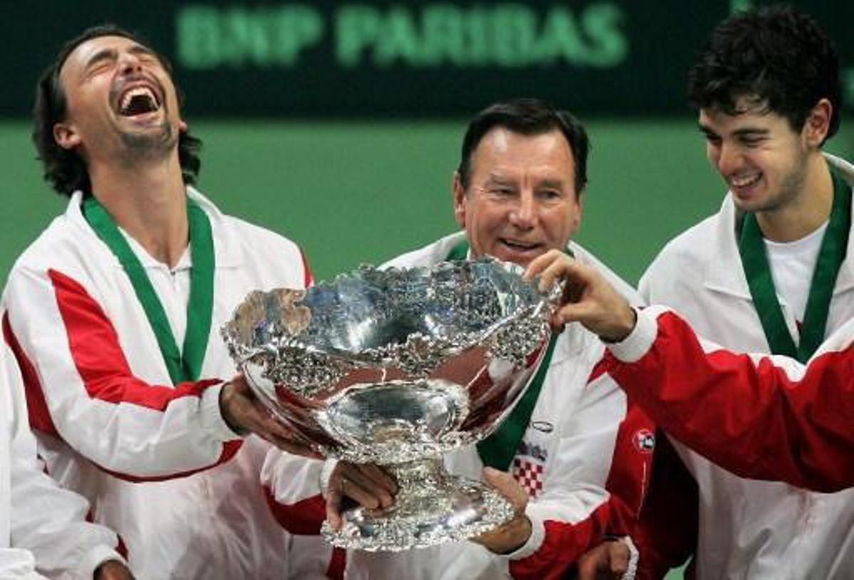 Croatian players Goran Ivanisevic (L), captain Nikola Pilic (C) and Mario Ancic hold the Davis Cup during the winner's ceremony following the Davis Cup finals between Slovakia and Croatia in Bratislava, 04 December 2005. Croatia won 3-2. AFP PHOTO/JOE KLAMAR