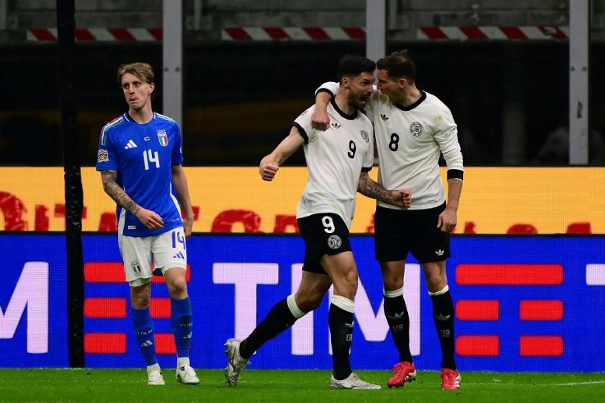 Germany's forward #09 Tim Kleindienst celebrates after scoring his team's first goal with Germany's midfielder #08 Leon Goretzka during the Nations League quarter final first leg football match between Italy and Germany at the San Siro Stadium in Milan, on March 20, 2025. Marco BERTORELLO / AFP