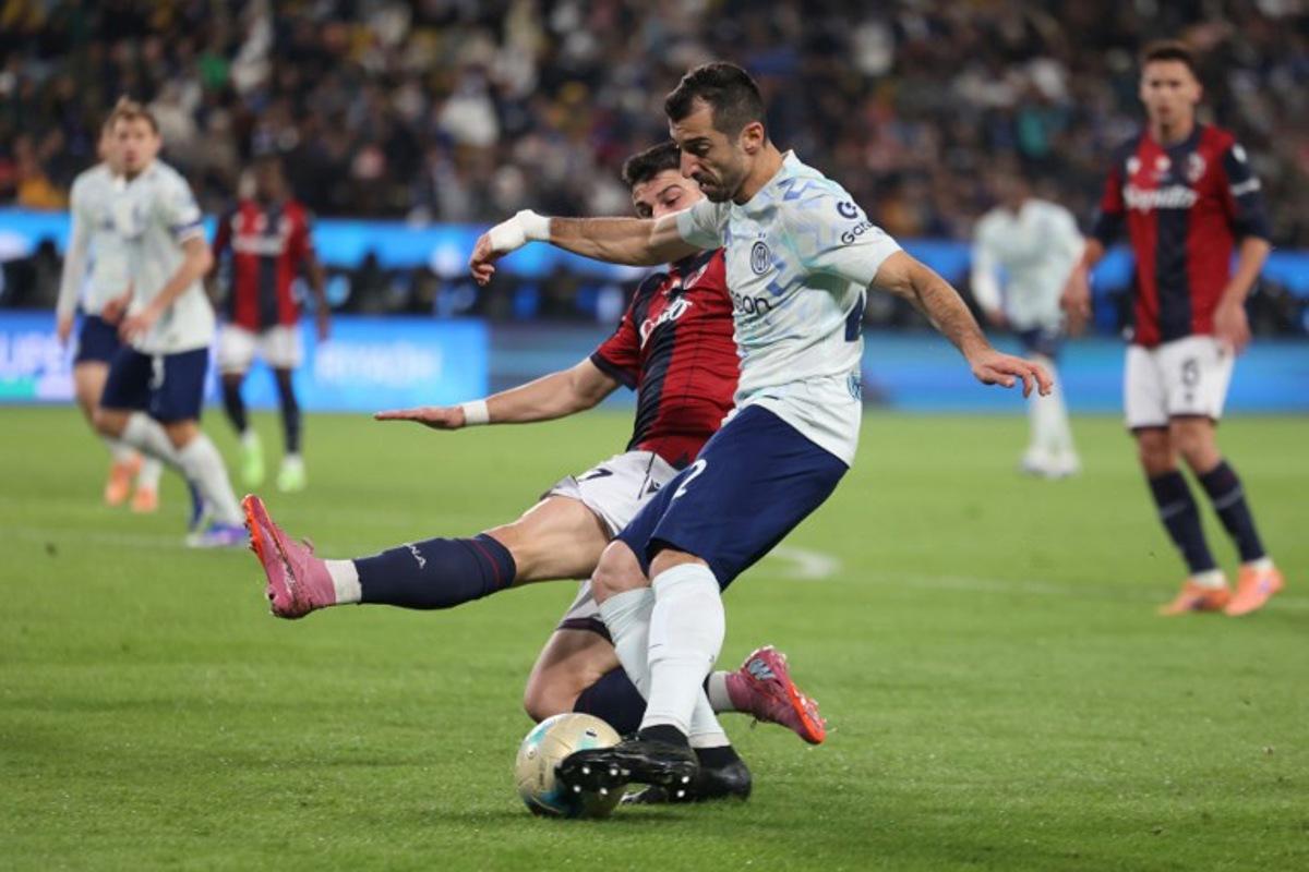 Inter Milan's Armenian forward #22 Henrikh Mkhitaryan (R) is tackled by Bologna's Italian forward #07 Riccardo Orsolini (L) during the Italian Super Cup semi-final match between Inter Milan and Bologna FC 1909 at King Al-Awwal Park Stadium, in Riyadh on December 19, 2025. Fayez Nureldine / AFP