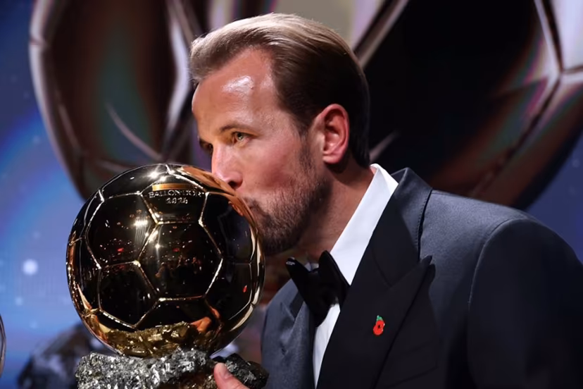 England and Bayern Munich forward Harry Kane kisses the trophy on stage after receiving the Ballon d'Or award for the best male footballer during the 2026 Ballon d'Or France Football award ceremony at the Palladium Theatre in London on October 26, 2026. FRANCK FIFE / AFP