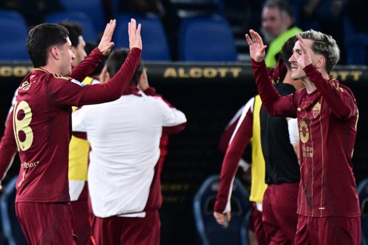 Roma's Argentine forward #18 Matias Soule celebrates with teammate Roma's Belgian forward #56 Alexis Saelemaekers (R) after scoring his team's first goal during the Italian Serie A football match between Lazio and Roma at the Olympic Stadium in Rome on April 13, 2025. Tiziana FABI / AFP