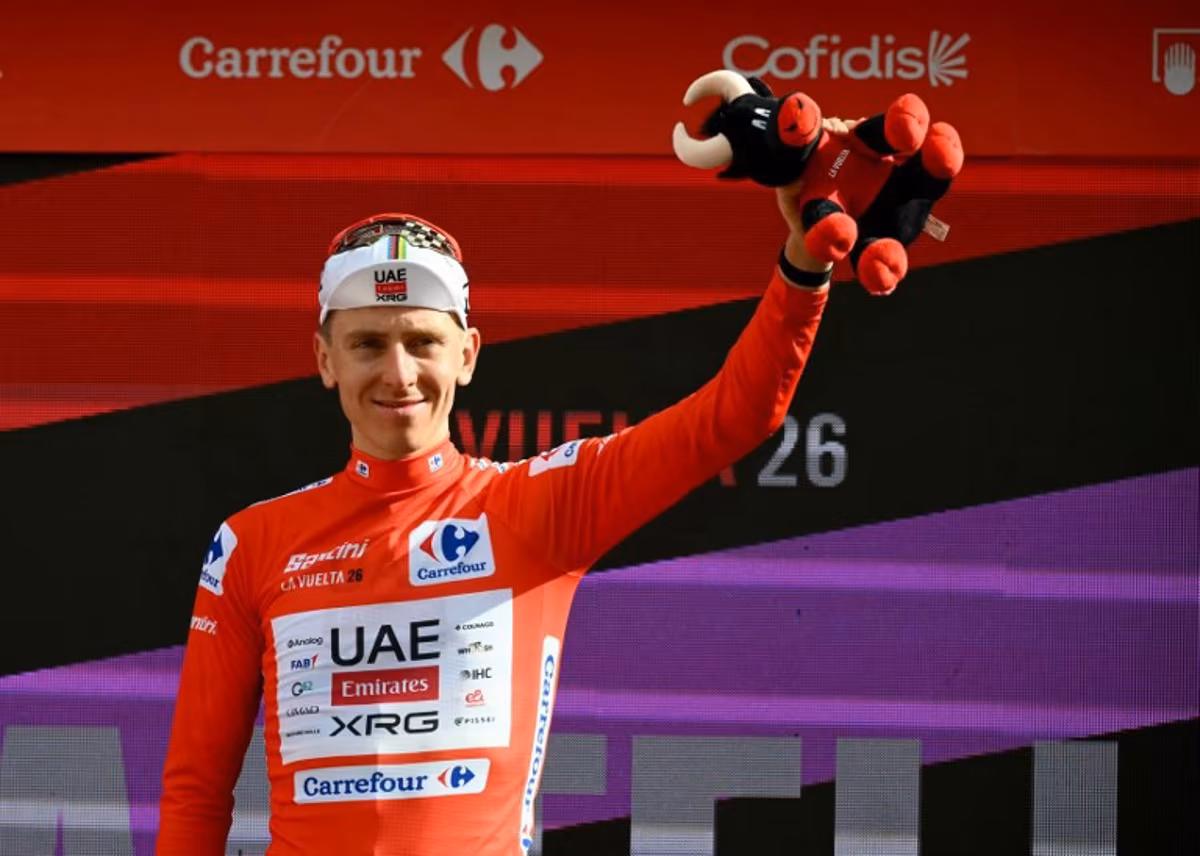Team UAE's Slovenian rider Tadej Pogacar wearing the overall leader red jersey celebrates on the podium the sixth stage of the Vuelta a Espana 2026, a 177,4 km race between Alcossebre and Castellon de la Plana on August 27, 2026. JOSE JORDAN / AFP