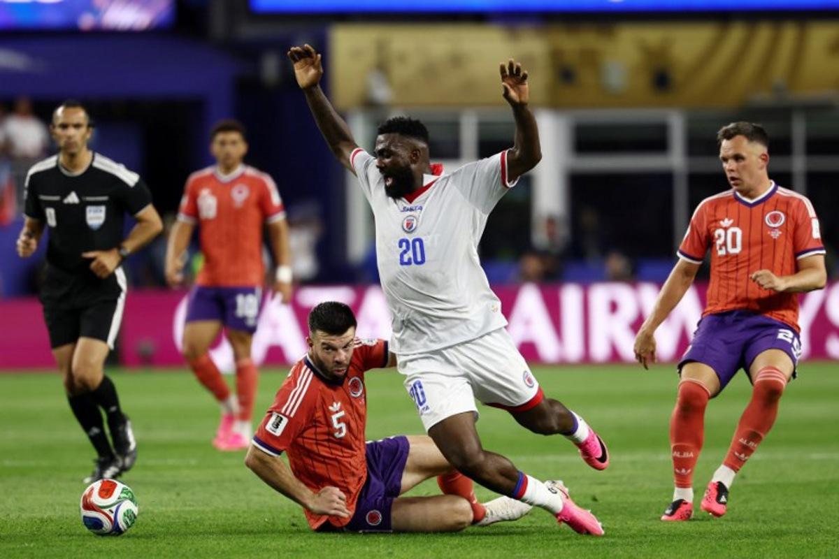 Scotland's defender #05 Grant Hanley and Haiti's forward #20 Frantzdy Pierrot fight for the ball during the 2026 World Cup Group C football match between Haiti and Scotland at the Boston Stadium in Foxborough on June 13, 2026. FRANCK FIFE / AFP