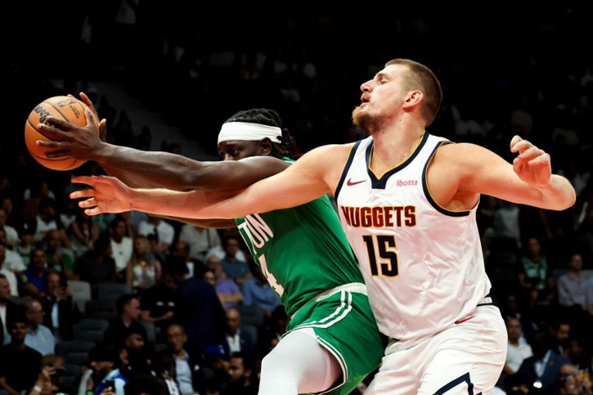 Boston Celtics' guard #04 Jrue Holiday fights for the ball with Denver Nuggets' center #15 Nikola Jokic during the NBA Preseason game between the Boston Celtics and the Denver Nuggets at the Etihad Arena in Abu Dhabi on October 6, 2024. Fadel Senna / AFP