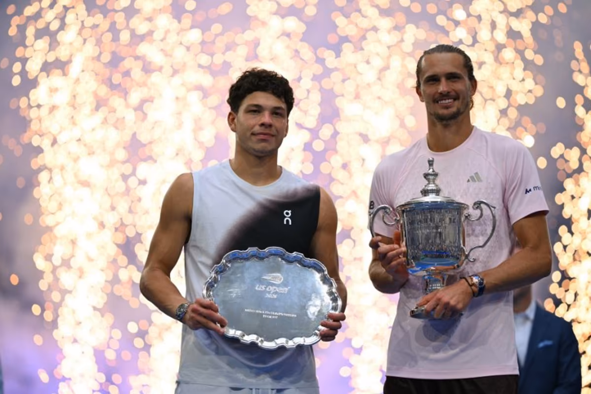 USA's Ben Shelton holds the runner-up trophy next to Germany's Alexander Zverev who holds the winner's trophy after the men's singles final tennis match on day fifteen of the US Open tennis tournament at the USTA Billie Jean King National Tennis Center in New York City on September 13, 2026. ANGELA WEISS / AFP