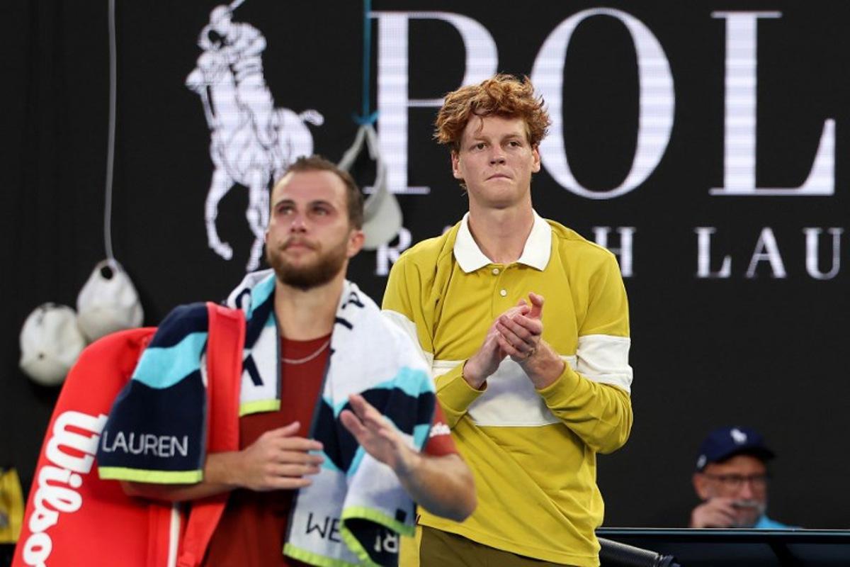 Italy's Jannik Sinner (L) applauds France's Hugo Gaston as Gaston walks off the court following their men's singles match on day three of the Australian Open tennis tournament in Melbourne on January 20, 2026. Martin KEEP / AFP