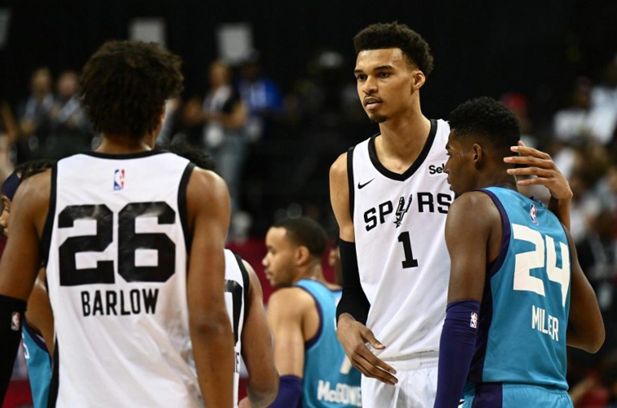 San Antonio Spurs' Victor Wembanyama (C) stands with Charlotte Hornets' Brandon Miller (R) and San Antonio Spurs' Dominick Barlow (L) at the end of the NBA Summer League game between the San Antonio Spurs and Charlotte Hornets, at the Thomas and Mack Center in Las Vegas, Nevada, on July 7, 2023. Patrick T. Fallon / AFP