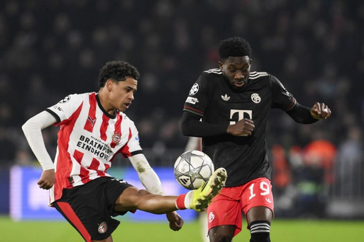 PSV Eindhoven's Belgian midfielder #31 Noah Fernandez (L) fights for the ball with Bayern Munich's Canadian defender #19 Alphonso Davies during the UEFA Champions League league phase day 8 football match between PSV Eindhoven and Bayern Munich at Philips Stadion in Eindhoven on January 28, 2026. JOHN THYS / AFP