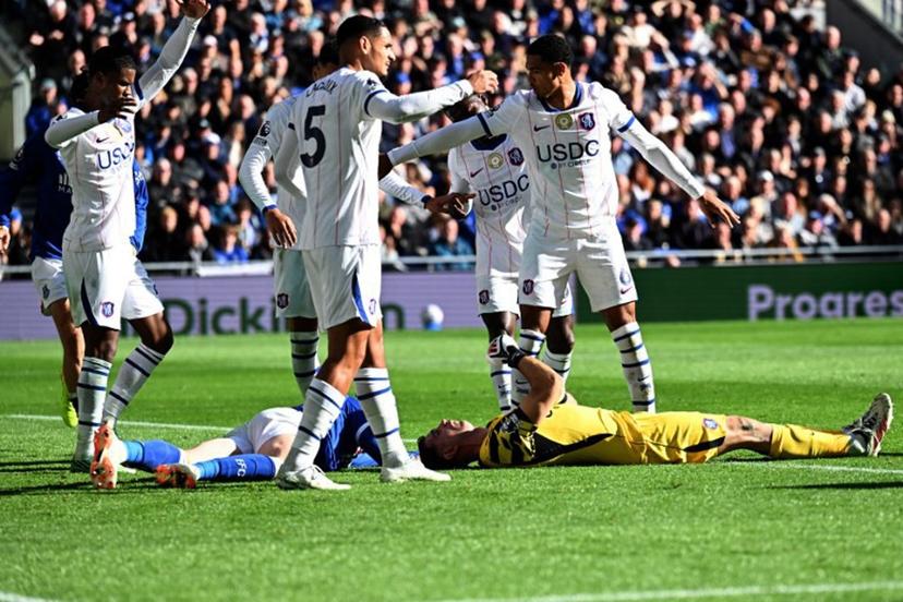 Chelsea's Argentinian goalkeeper #26 Emiliano Martinez and Everton's English defender #04 Jarrad Branthwaite lie injured after a clash during the English Premier League football match between Everton and Chelsea at Hill Dickinson Stadium in Liverpool, north west England on October 17, 2026. PETER POWELL / AFP