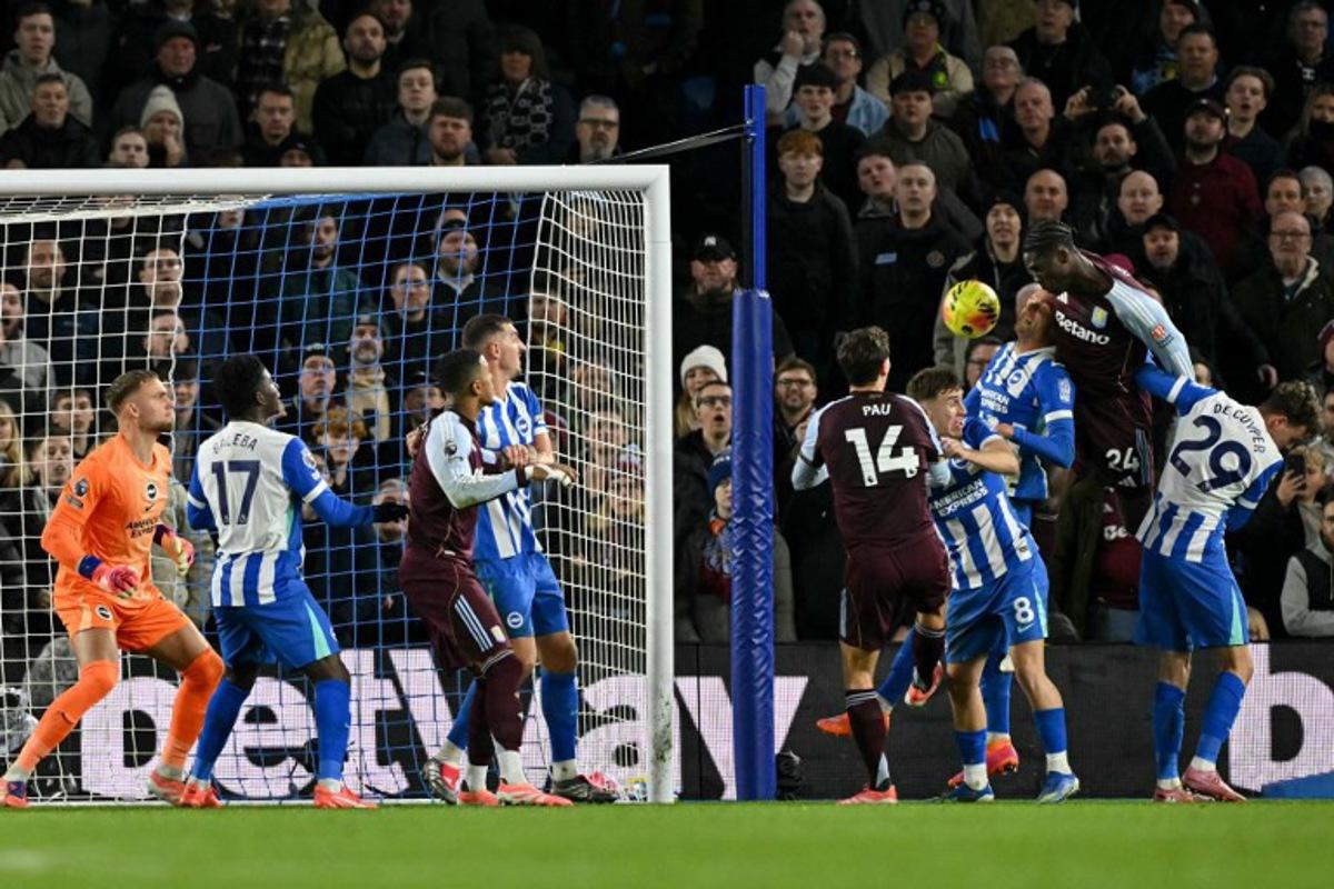 Aston Villa's Belgian midfielder #24 Amadou Onana (2nd R) goes for a header and scores his team's third goal during the English Premier League football match between Brighton and Hove Albion and Aston Villa at the American Express Community Stadium in Brighton, southern England on December 3, 2025. Glyn KIRK / AFP