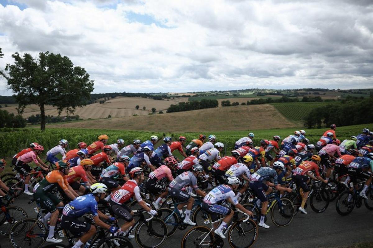 The pack of riders (peloton) cycles during the 13th stage of the 111th edition of the Tour de France cycling race, 165,3 km between Agen and Pau, southwestern France, on July 12, 2024. Anne-Christine POUJOULAT / AFP