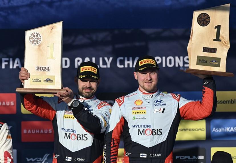 Winner Esapekka Lappi of Finland and his co-driver Janne Ferm of Finland pose with their trophies on the podium of the FIA World Rally Championship near Umea, Sweden, on February 18, 2024. Jonathan NACKSTRAND / AFP