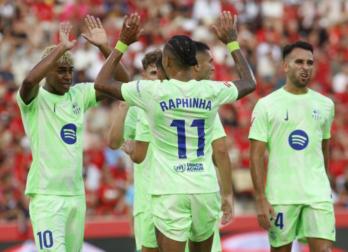 Barcelona's Brazilian forward #11 Raphinha celebrates with Barcelona's Spanish forward #10 Lamine Yamal after scoring the opening goal during the Spanish league football match between RCD Mallorca and FC Barcelona at Mallorca Son Moix Stadium in Palma de Mallorca on August 16, 2025. JAIME REINA / AFP