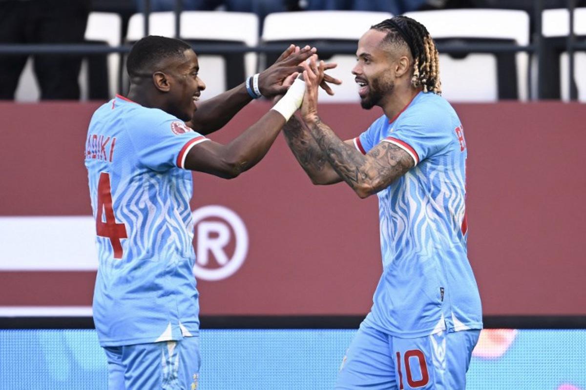 Democratic Republic Of Congo's forward #10 Theo Bongonda celebrates his goal with Democratic Republic Of Congo's midfielder #14 Noah Sadiki during the Africa Cup of Nations (CAN) Group D football match between Democratic Republic of Congo and Benin at Al Medina Stadium in Rabat on December 23, 2025. SEBASTIEN BOZON / AFP