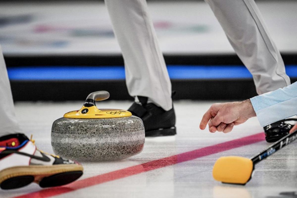 USA's John Shuster curls the stone during the men's bronze medal game of the Beijing 2022 Winter Olympic Games curling competition between Canada and USA at the National Aquatics Centre in Beijing on February 18, 2022. Jeff PACHOUD / AFP