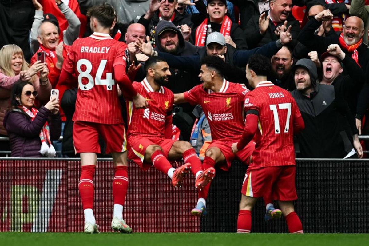 Liverpool's Colombian midfielder #07 Luis Diaz (2nd R) celebrates with Liverpool's English midfielder #17 Curtis Jones (R), Liverpool's Egyptian striker #11 Mohamed Salah and Liverpool's Northern Irish defender #84 Conor Bradley after scoring his team first goal during the English Premier League football match between Liverpool and West Ham United at Anfield in Liverpool, north west England on April 13, 2025. Paul ELLIS / AFP