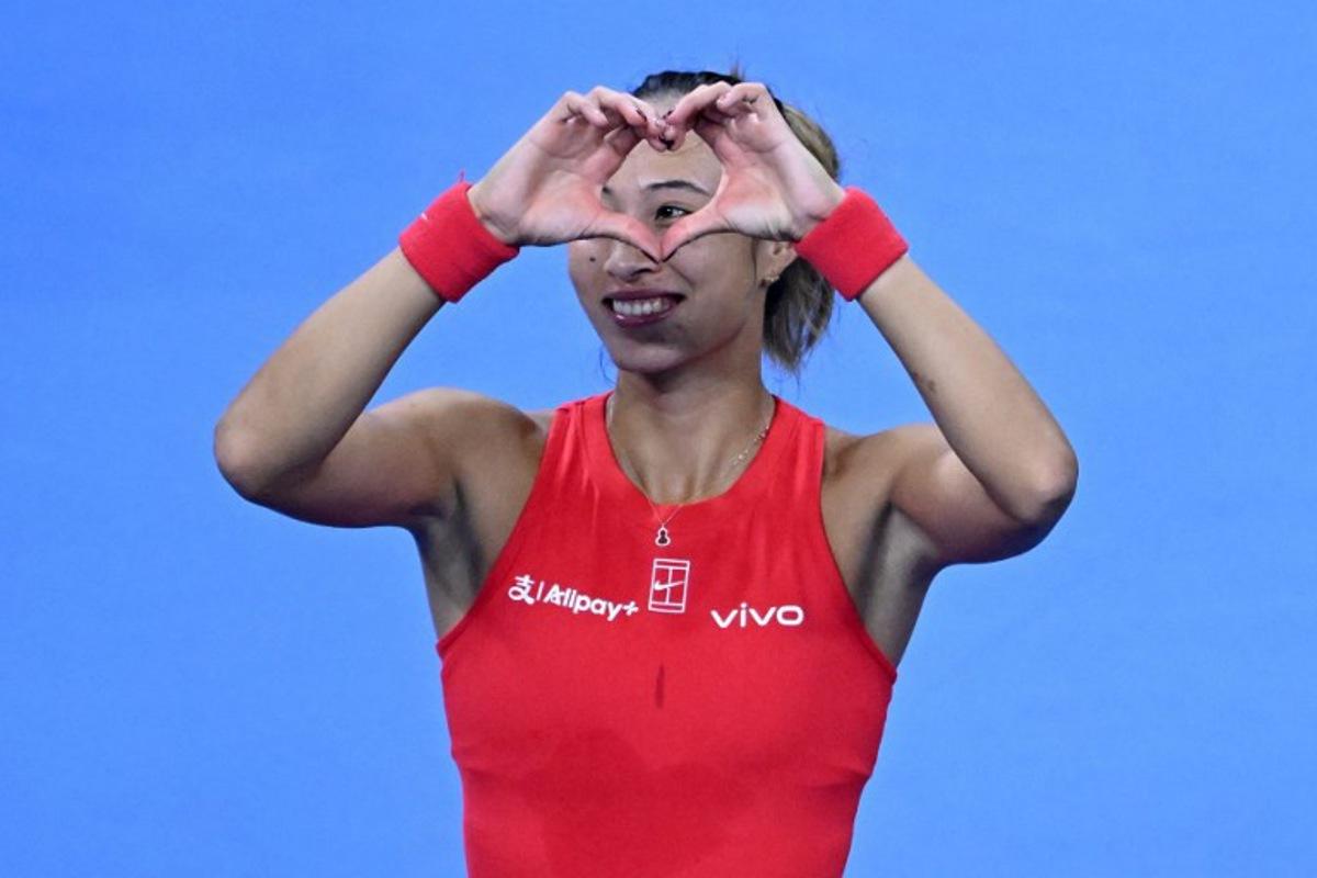 China's Zheng Qinwen make a heart sign to spectators for her birthday wishes as she celebrates beating Armenia's Alina Charaeva in their women's singles match at the China Open tennis tournament in Beijing on October 7, 2026. ADEK BERRY / AFP