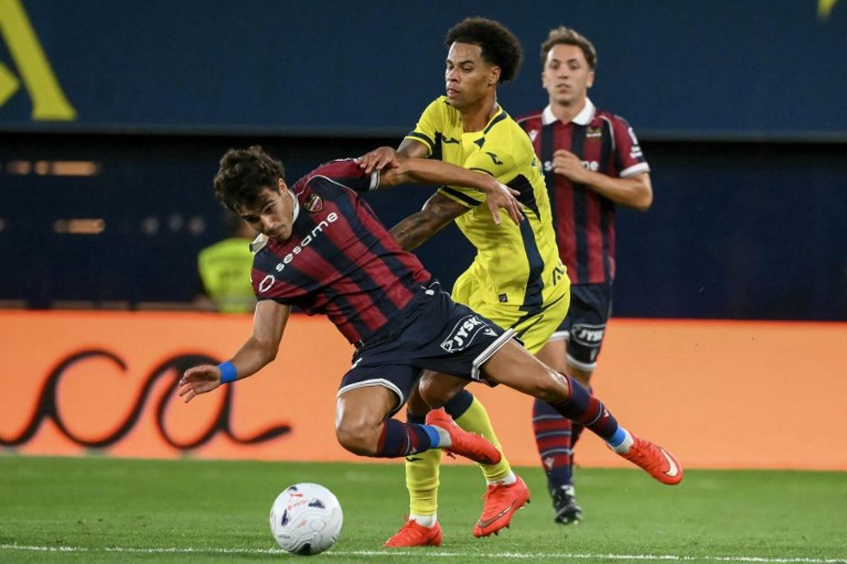 Levante's Spanish defender #23 Manuel Sanchez (L) is challenged by Villarreal's Canadian midfielder #17 Tajon Buchanan during the Spanish league football match between Villarreal CF and Levante UD at La Ceramica Stadium in Vila-real on September 20, 2026. JOSE JORDAN / AFP