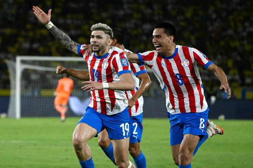 Paraguay's forward #19 Julio Enciso (L) celebrates next to teammate midfielder #08 Diego Gomez after scoring his team second goal during the 2026 FIFA World Cup South American qualifiers football match between Colombia and Paraguay at the Metropolitano Roberto Melendez stadium in Barranquilla, Colombia, on March 25, 2025. Luis ACOSTA / AFP