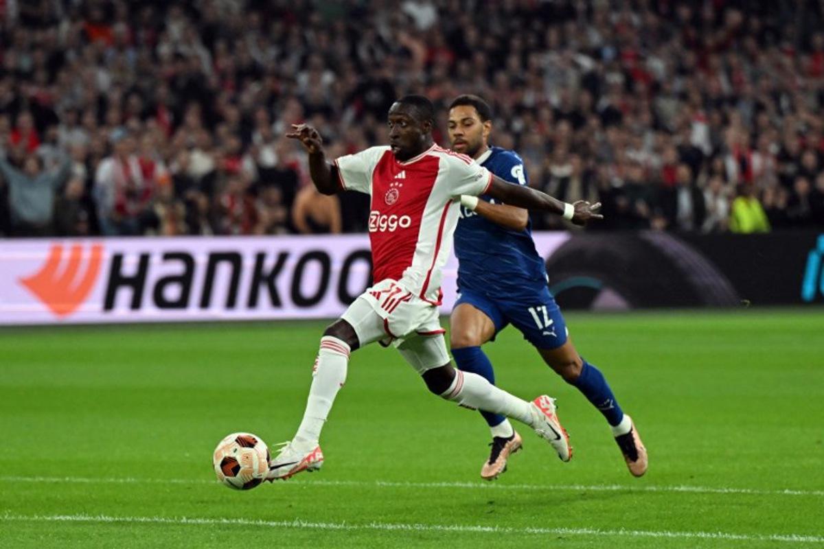 Ajax' forward #11 Portuguese Carlos Forbs (L) fights for the ball with Marseille's Italian-Brazilian defender #12 Renan Lodi (R) during the Europa League Group B football match between AFC Ajax and Olympique Marseille at Johan Cruijff ArenA in Amsterdam, on September 21, 2023. Olaf Kraak / ANP / AFP