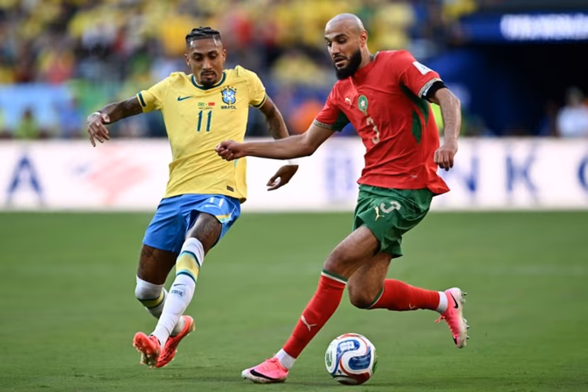 Brazil's forward #11 Raphinha and Morocco's defender #03 Noussair Mazraoui fight for the ball during the 2026 World Cup Group C football match between Brazil and Morocco at the New York/New Jersey Stadium in East Rutherford on June 13, 2026. Jewel SAMAD / AFP