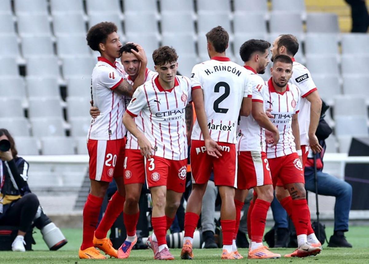 Girona's Belgian defender #20 Axel Witsel celebrates scoring his team's first goal with teammates during the Spanish league football match between FC Barcelona and Girona FC at Estadi Olimpic Lluis Companys in Barcelona on October 18, 2025. Josep LAGO / AFP