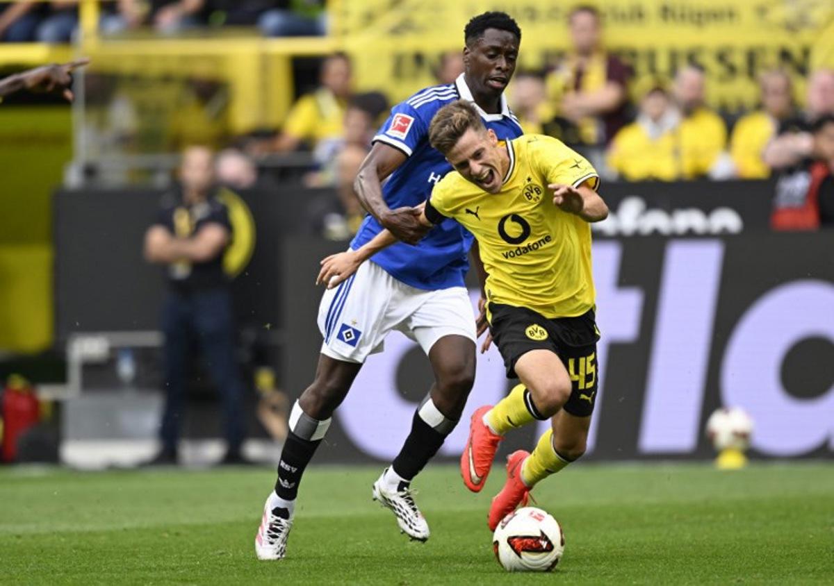 Hamburg's Belgian-Congolese midfielder #06 Albert Sambi Lokonga and Dortmund's Greek midfielder #45 Giannis Konstantelias vie for the ball during the German first division Bundesliga football match between BVB Borussia Dortmund and Hamburg SV in Dortmund, western Germany on August 29, 2026. INA FASSBENDER / AFP