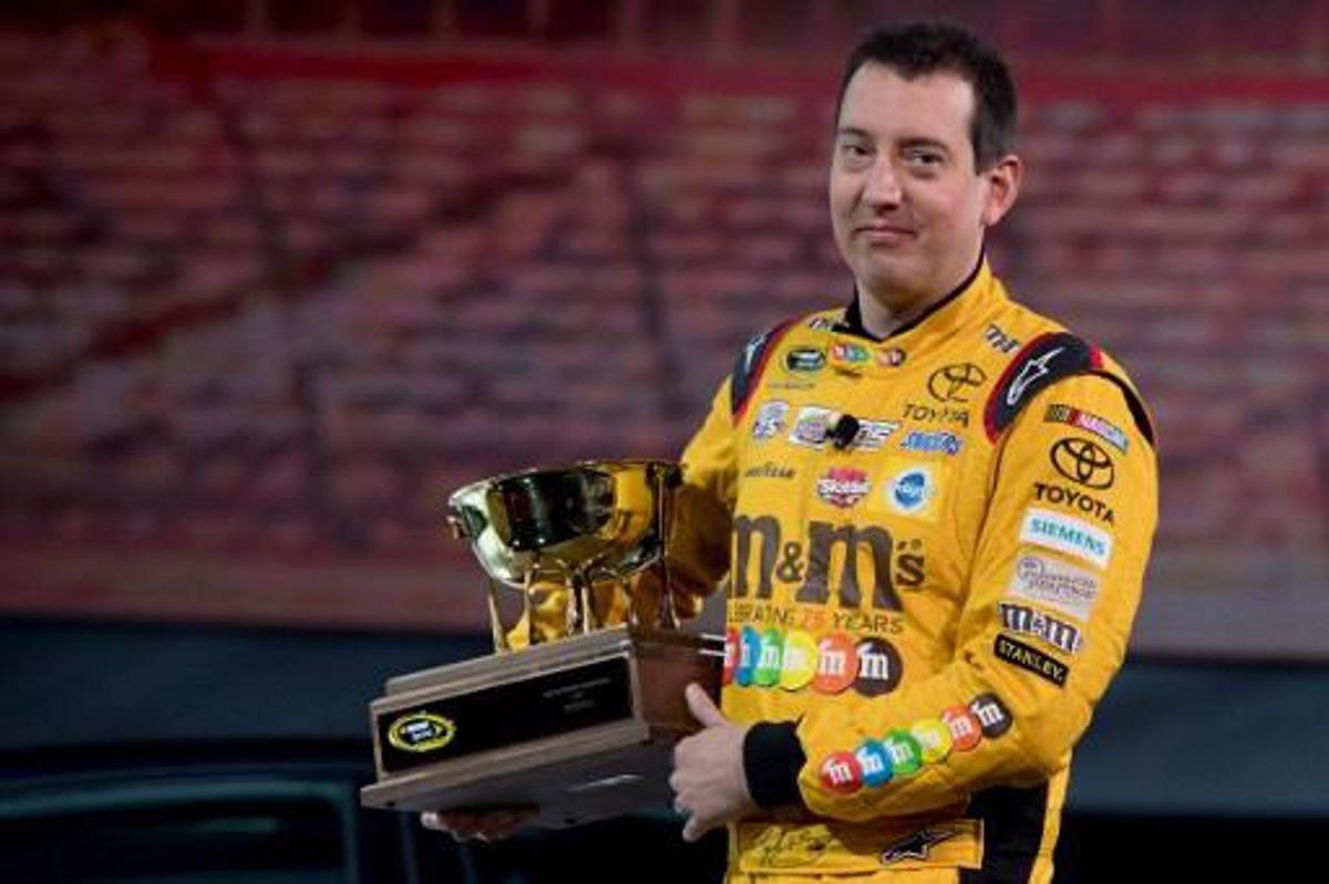 2015 NASCAR Sprint Cup Series Champion Kyle Busch carries the 2016 NASCAR Manufacturers Trophy at the Toyota press conference during the 2017 North American International Auto Show in Detroit, Michigan, January 9, 2017.
JIM WATSON / AFP