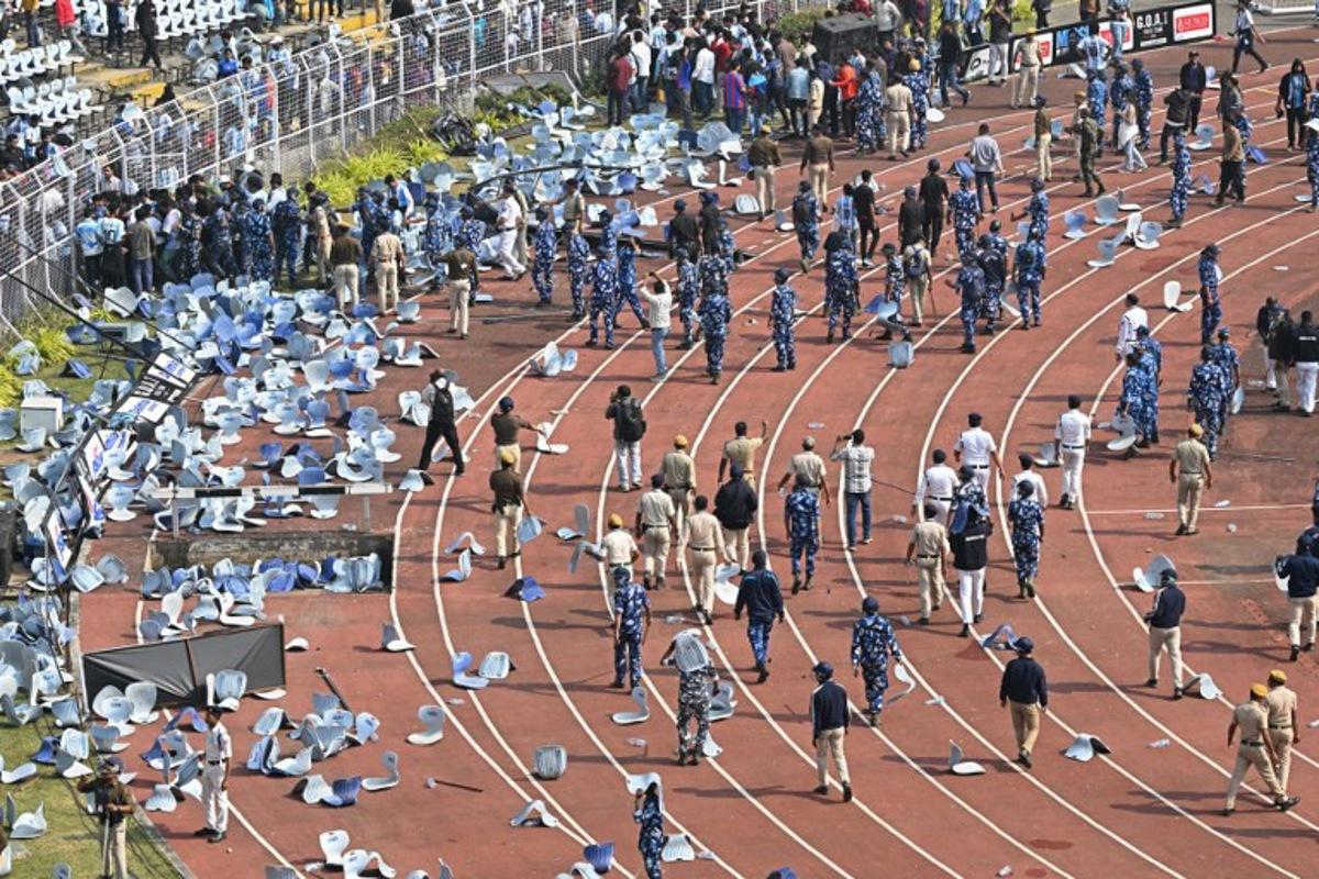 Security personnel try to control the crowd as Inter Miami's Argentine forward #10 Lionel Messi departs from the Salt Lake Stadium in Kolkata on December 13, 2025. Thousands of fans packed into a stadium in eastern India on December 13 to cheer on Lionel Messi as the football legend unveiled a 21-metre (70-foot) statue of himself. Dibyangshu SARKAR / AFP