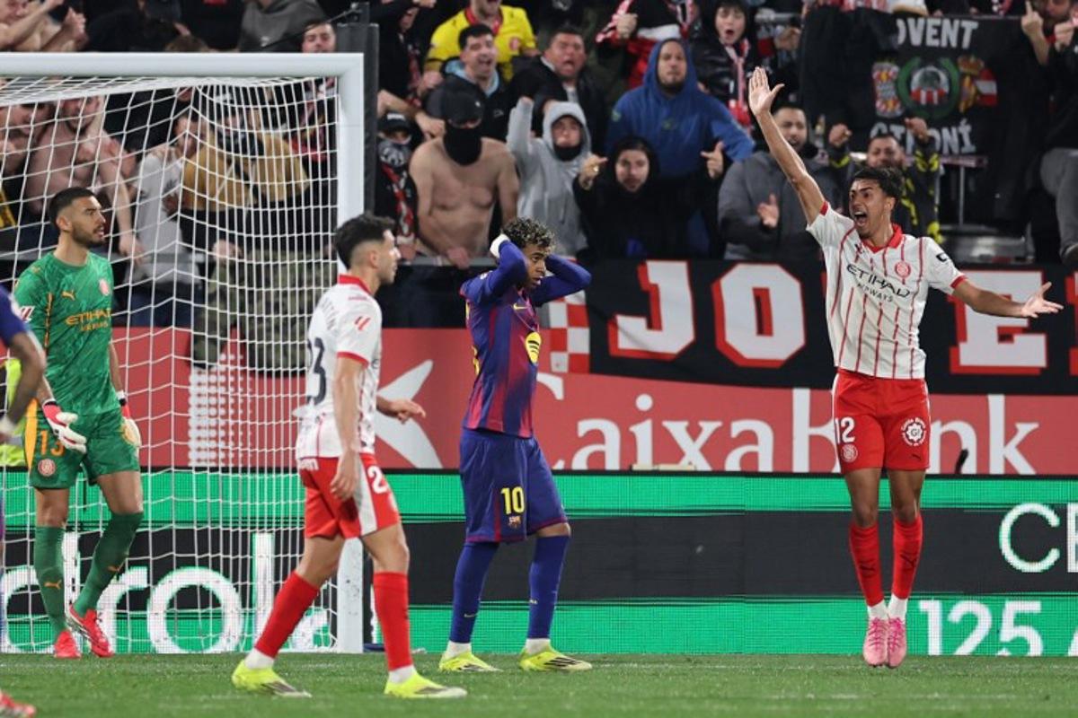 Barcelona's Spanish forward #10 Lamine Yamal reacts after failing to score a penalty kick during the Spanish league football match between Girona FC and FC Barcelona at Montilivi Stadium in Girona on February 16, 2026. Josep LAGO / AFP