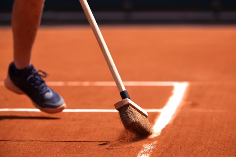 A staff member sweeps the clay on a court during the French Open tennis tournament at the Roland Garros Complex in Paris on May 26, 2024. Anne-Christine POUJOULAT / AFP