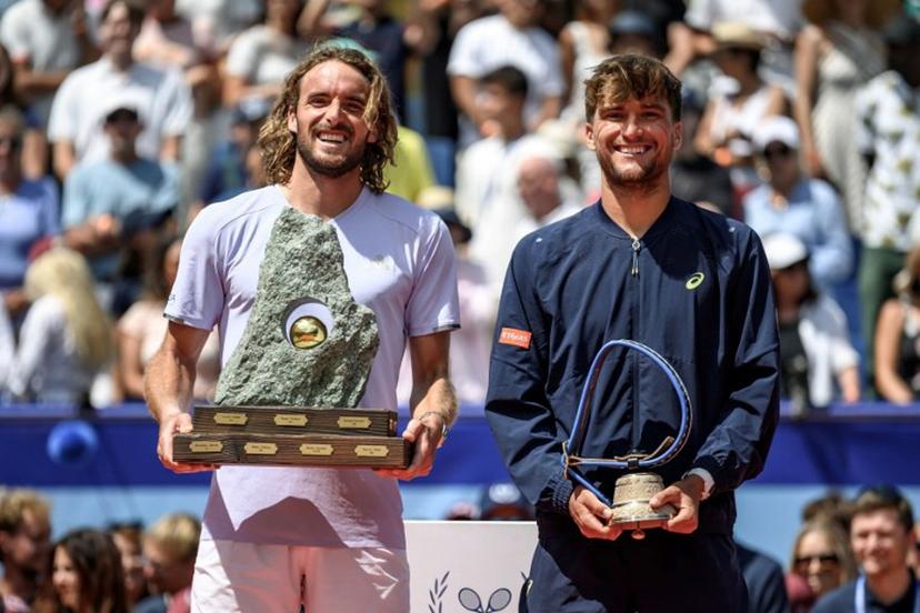Greece's Stefanos Tsitsipas (L) poses with the trophy following his victory against Belgium's Raphael Collignon (R) during their men's singles final match at the Swiss Open tennis tournament in Gstaad, on July 19, 2026. Fabrice COFFRINI / AFP