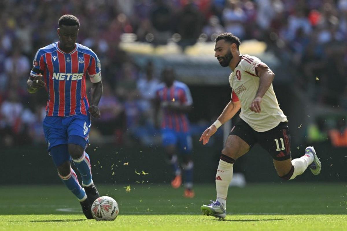 Liverpool's Egyptian striker #11 Mohamed Salah (R) vies with Crystal Palace's English defender #06 Marc Guehi (L) during the English FA Community Shield football match between Crystal Palace and Liverpool at Wembley Stadium, in London on August 10, 2025. Glyn KIRK / AFP
