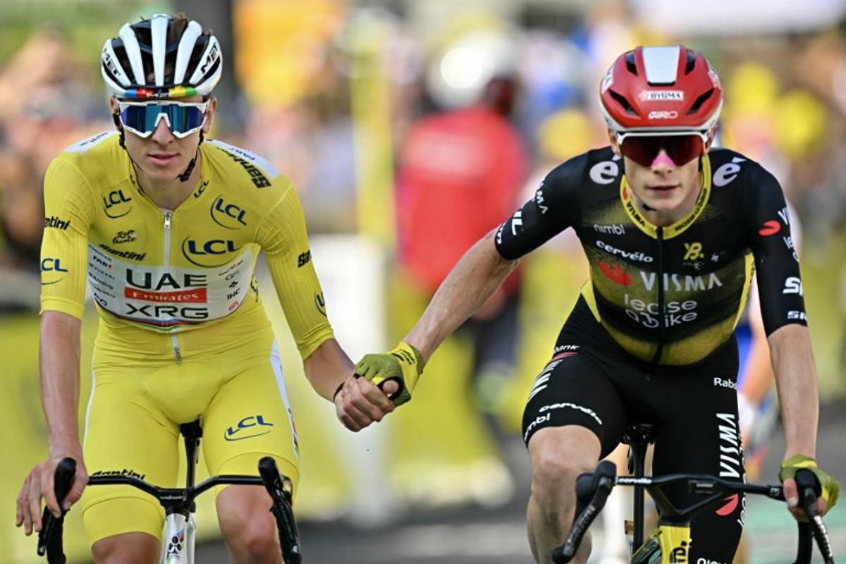 UAE Team Emirates - XRG team's Slovenian rider Tadej Pogacar wearing the overall leader's yellow jersey (L) and Team Visma - Lease a bike team's Danish rider Jonas Vingegaard (R) cross the finish line hand in hand after the 10th stage of the 112th edition of the Tour de France cycling race, 165.3 km between Ennezat and Le Mont-Dore Puy de Sancy, in central France, on July 14, 2025. Loic VENANCE / AFP