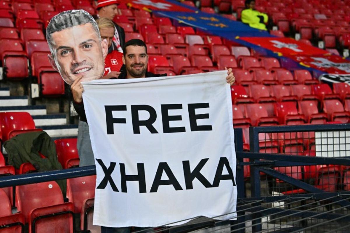 A fan of Switzerland's midfielder Granit Xhaka hlds up a banner in the crowd ahead of the UEFA Nations League, League B, Group 1 match football match between Scotland and Switzerland at Hampden Park in Glasgow, Scotland on September 29, 2026. ANDY BUCHANAN / AFP